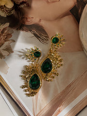Gold-tone emerald green crystal-style teardrop stud earrings close view