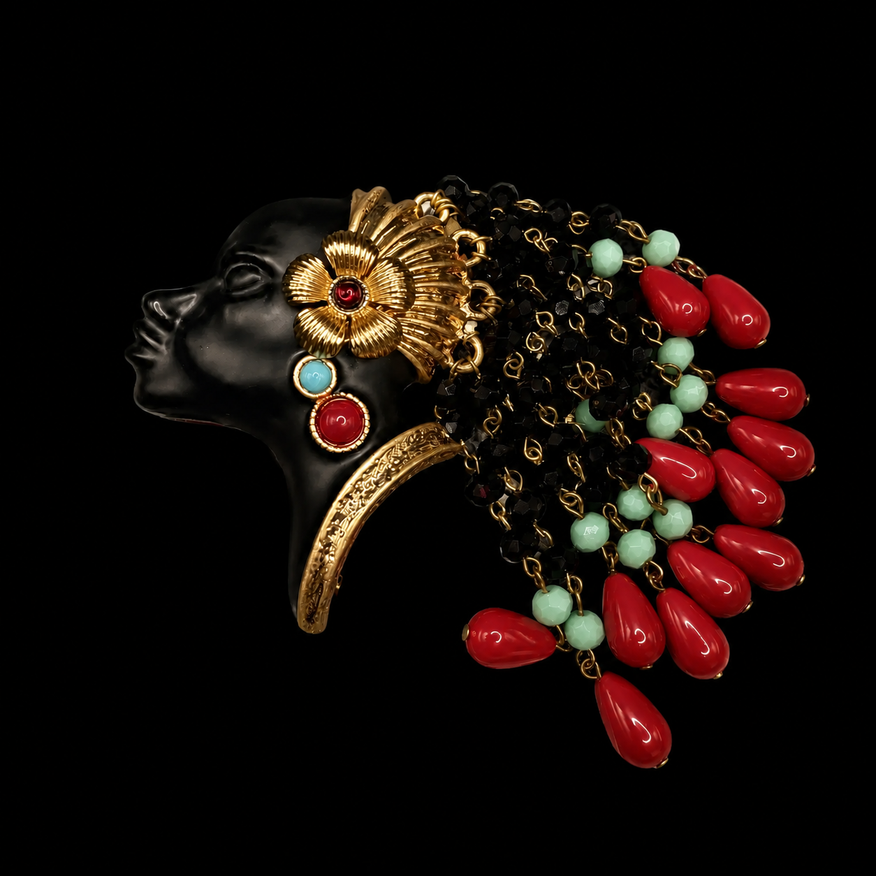Gold-tone face tassel enamel-style resin bead brooch with red teardrop beads angled view