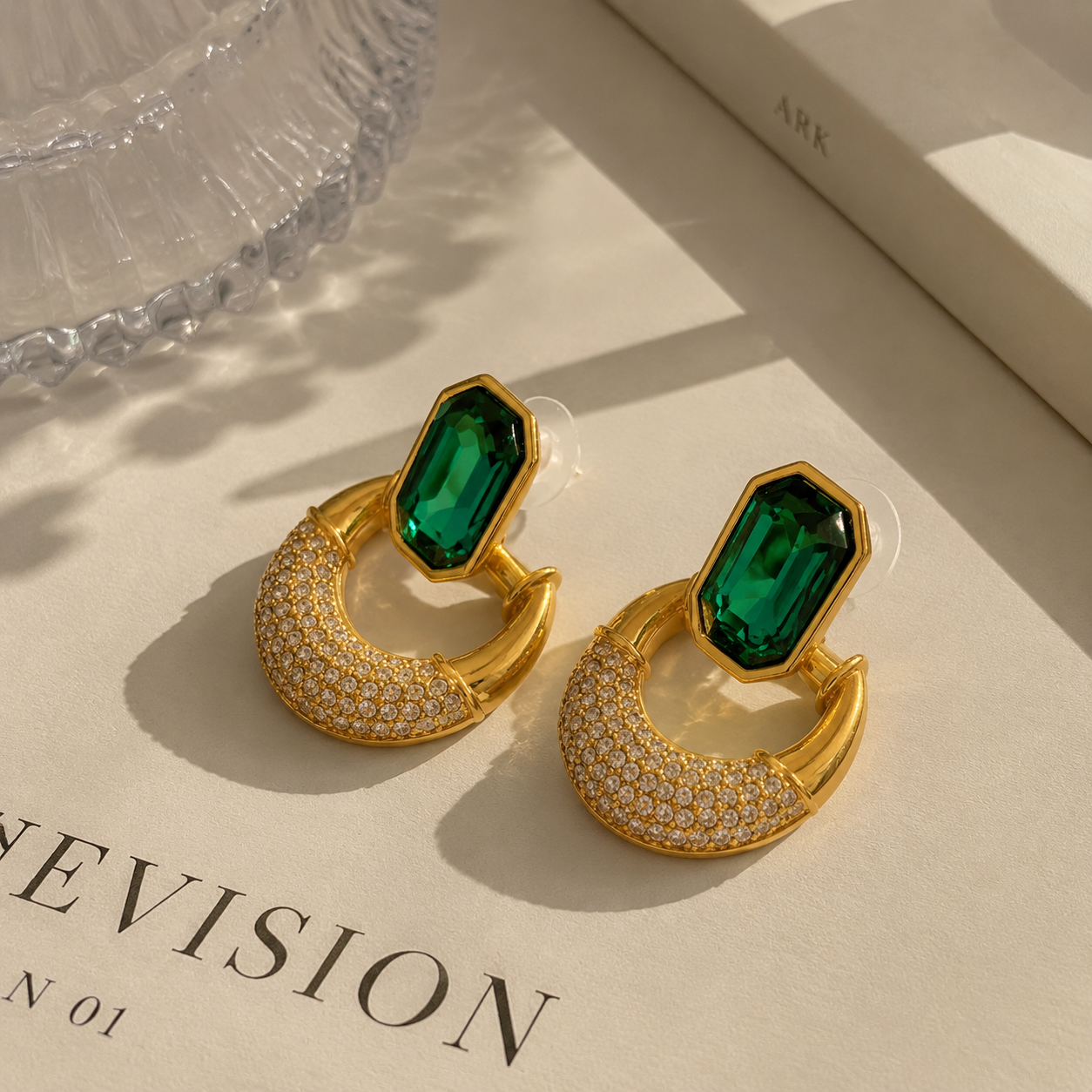 Gold-tone faceted glass crescent stud earrings in emerald green front view