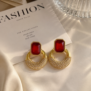 Gold-tone faceted glass crescent stud earrings in ruby red front view