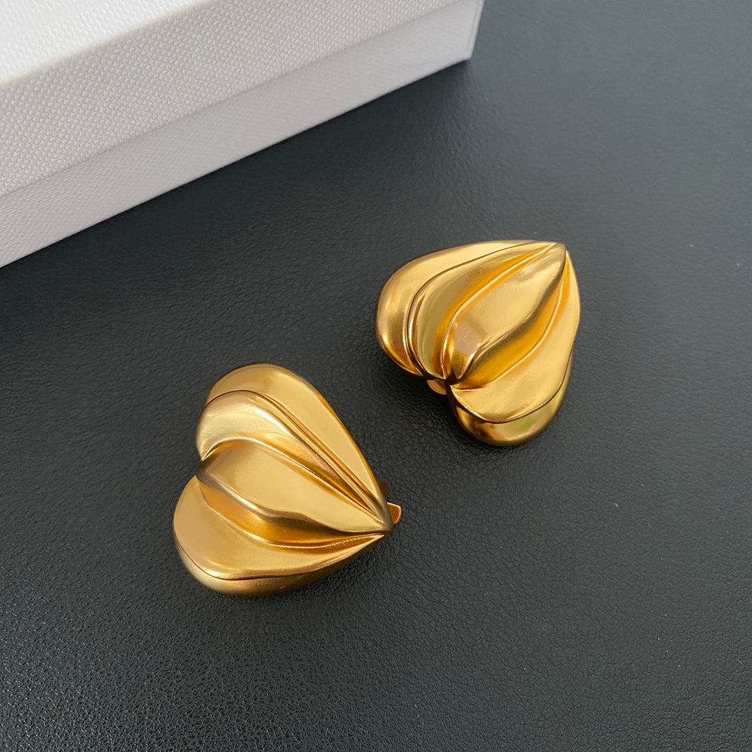 Gold-tone sculptural folded heart clip-on earrings close-up