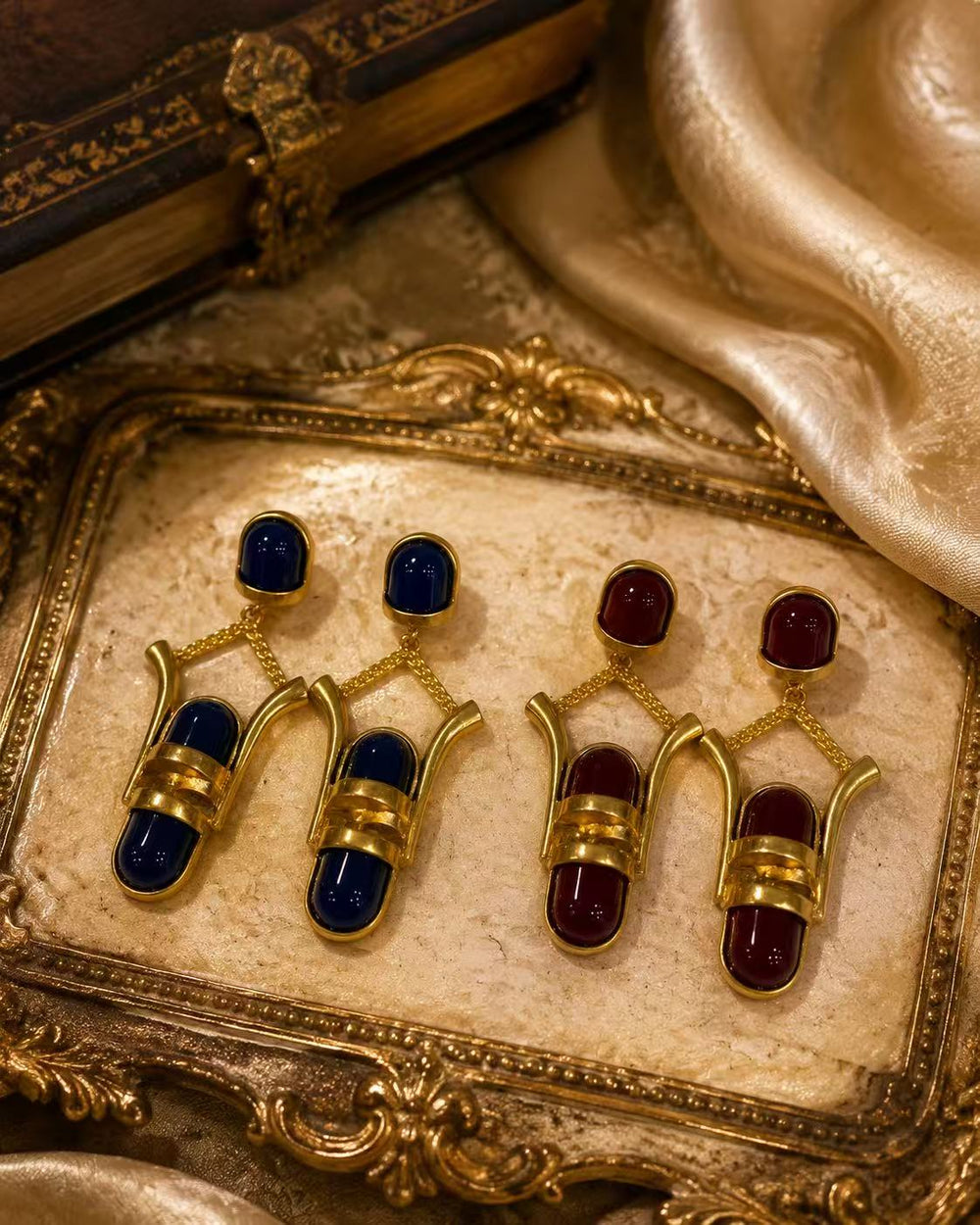 Gold-tone geometric glass-style drop stud earrings in burgundy and navy blue