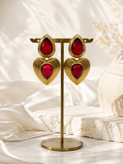 Red gold-tone glass heart drop stud earrings on display