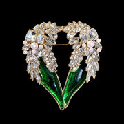 Gold-tone green crystal-style winged heart statement brooch front view