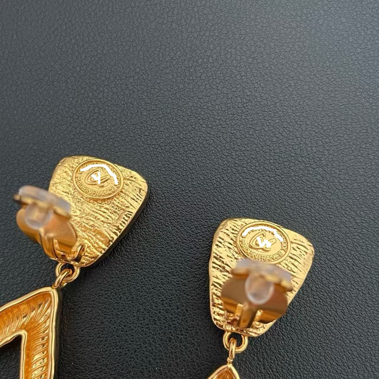 Back view of gold-tone green stone-style statement earrings showing clip-on backs