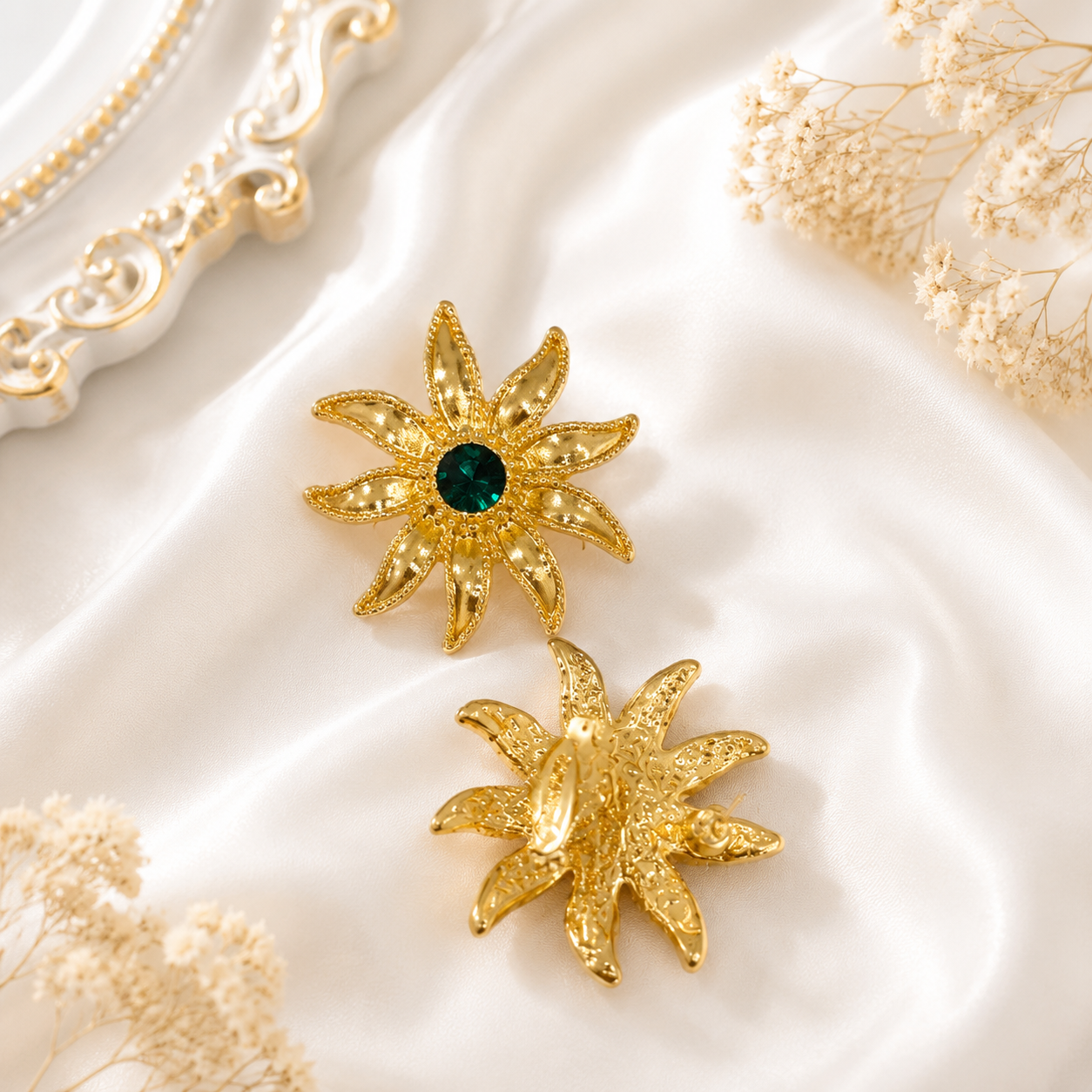 Front and back view of a gold-tone sunburst stud earring with a deep green crystal-style center