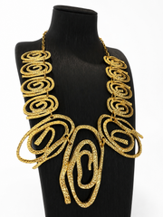 Gold-tone hammered swirl statement necklace angled detail view