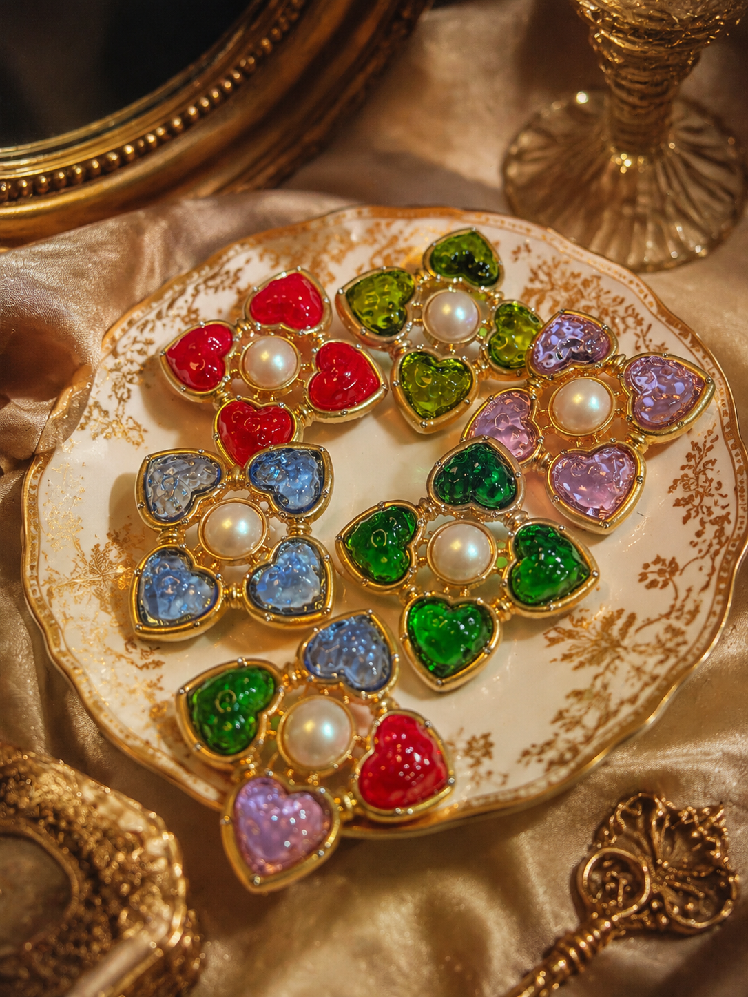 Gold-tone heart glass-style convertible brooch pendants in assorted colors on vintage plate