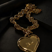 Close view of a gold-tone heart pendant and chain