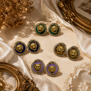 Gold-tone lion head crystal-style stud earrings in blue, khaki, purple, and green