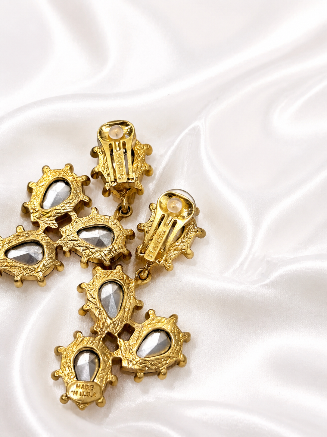 Back view of gold-tone orange rhinestone clip-on earrings with clip mechanisms