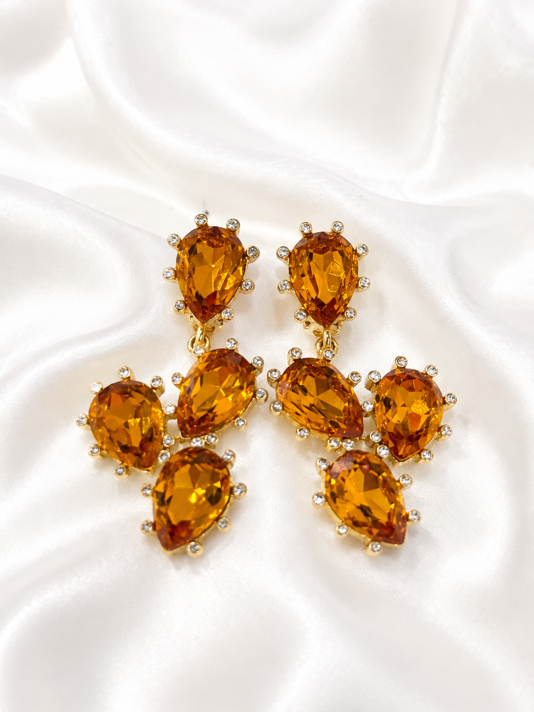 Close-up of gold-tone orange rhinestone clip-on earrings