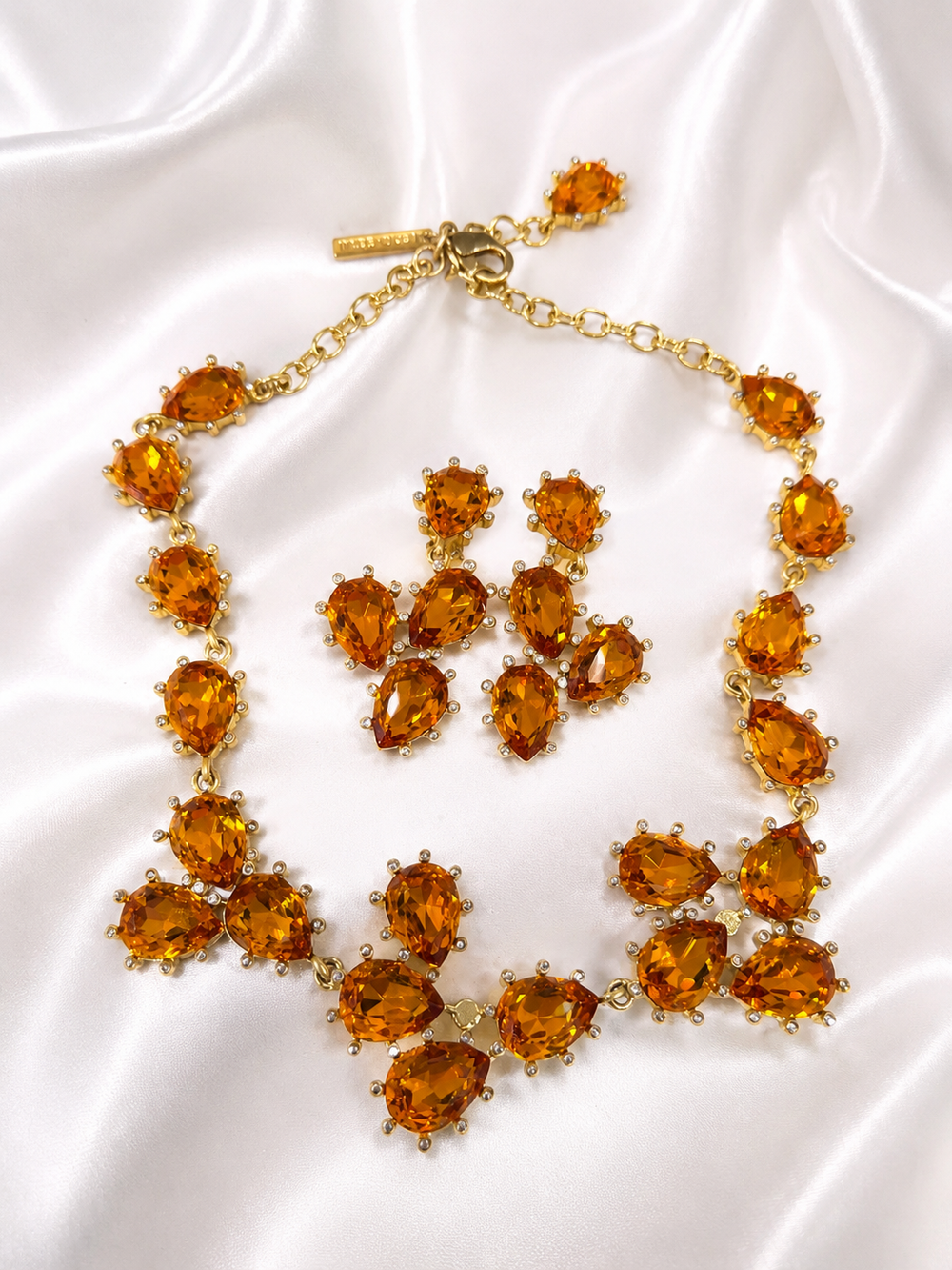 Gold-tone orange rhinestone necklace and clip-on earrings jewelry set front view