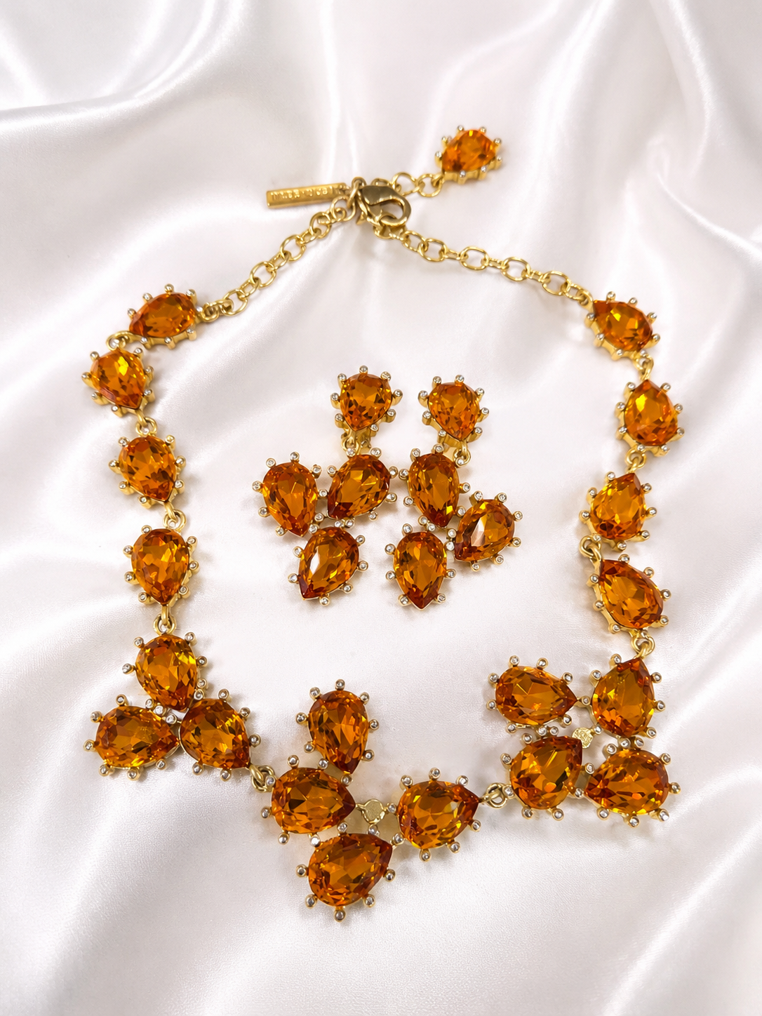 Gold-tone orange rhinestone necklace and clip-on earrings jewelry set front view