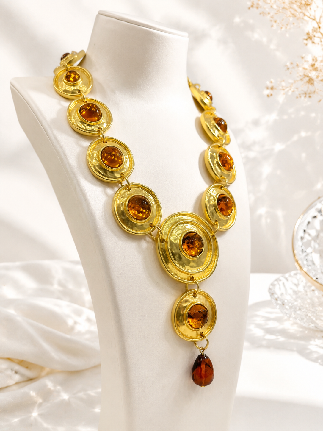 Close-up of gold-tone statement necklace with orange stone-style accents