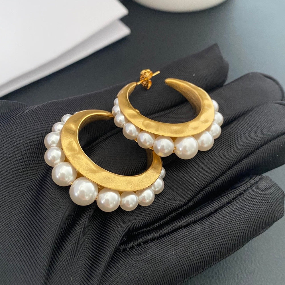 Gold-tone pearl-style crescent hoop stud earrings front view