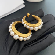 Gold-tone pearl-style crescent hoop stud earrings front view