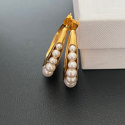 Gold-tone pearl-style crescent hoop stud earrings side view