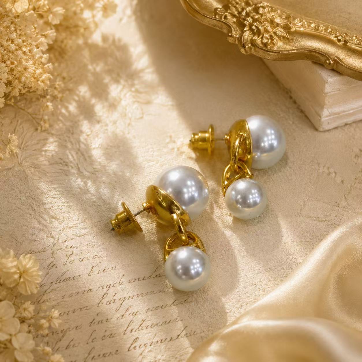 Gold-tone pearl-style-style double-sphere drop stud earrings detail view