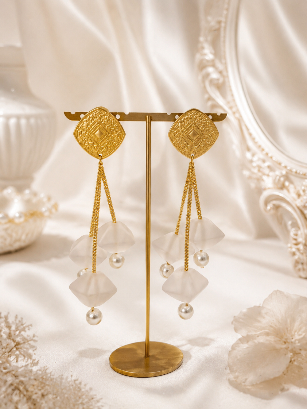 Pair of long gold-tone petal drop stud earrings with pearl-style beads, front view