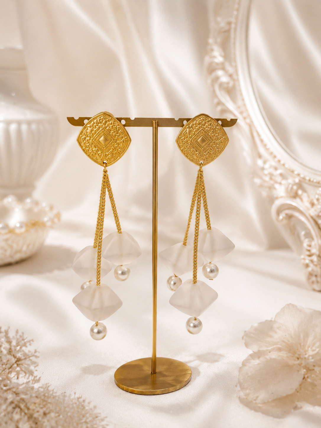 Pair of long gold-tone petal drop stud earrings with pearl-style beads, front view