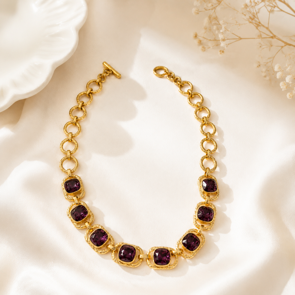 Gold-tone chain necklace with purple crystal-style accents front view