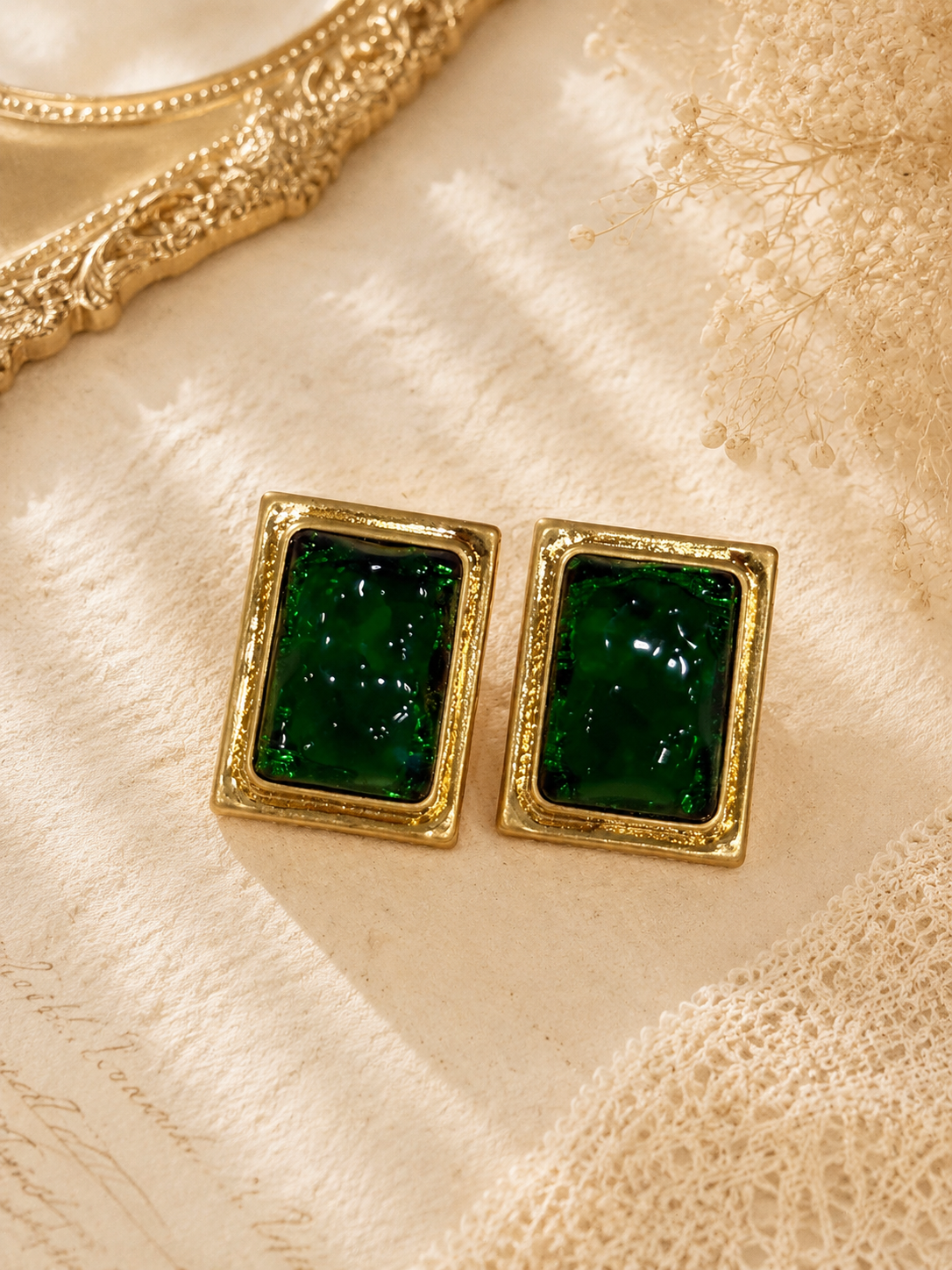 Gold-tone rectangular green glass-style stud earrings front view