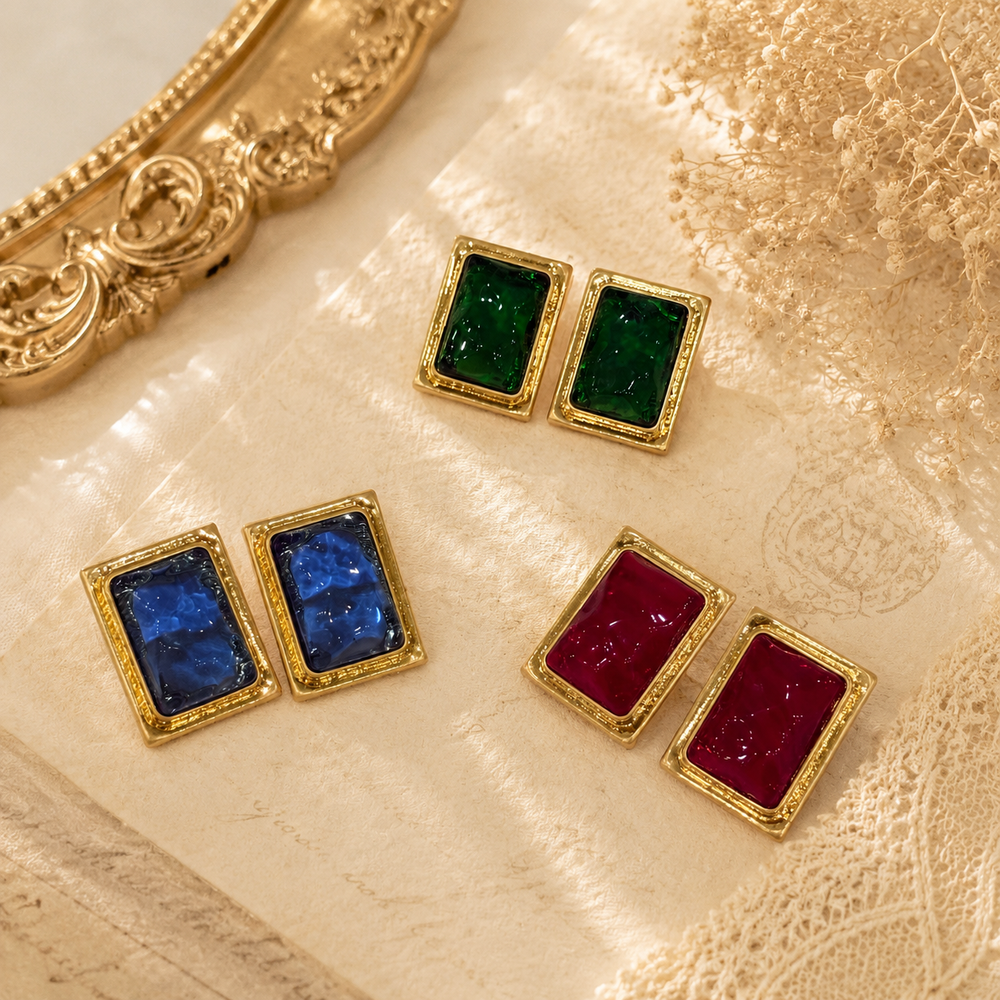 Gold-tone rectangular glass-style stud earrings in green, red, and blue