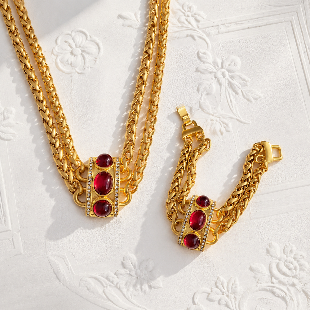 Gold-tone red stone-style chain necklace and bracelet set flat lay