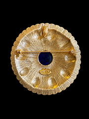 Back view of gold-tone round blue cabochon-style brooch pendant with pin and pendant loop