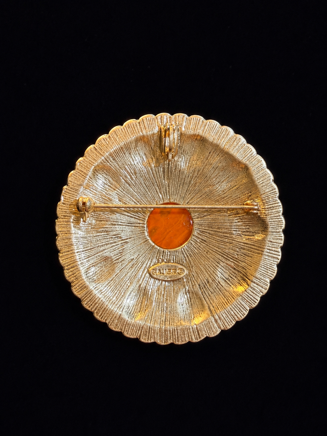 Back view of gold-tone round orange yellow cabochon-style brooch pendant with pin and pendant loop