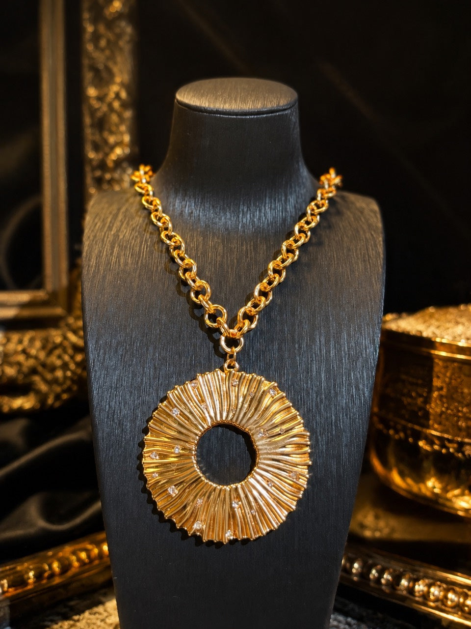 Gold-tone sculptural crystal-style-style pendant necklace on dark display