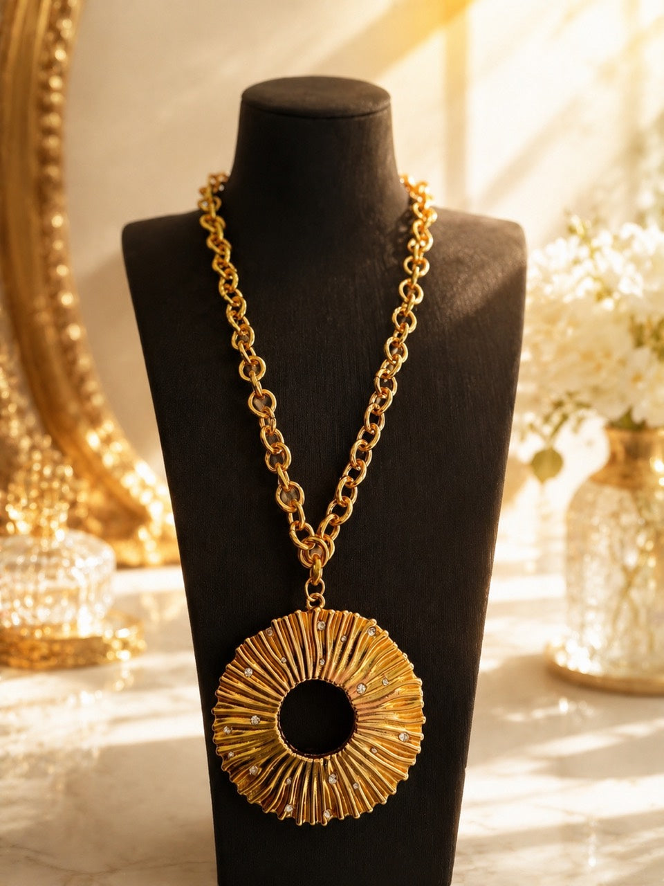 Gold-tone sculptural crystal-style-style pendant necklace on warm display