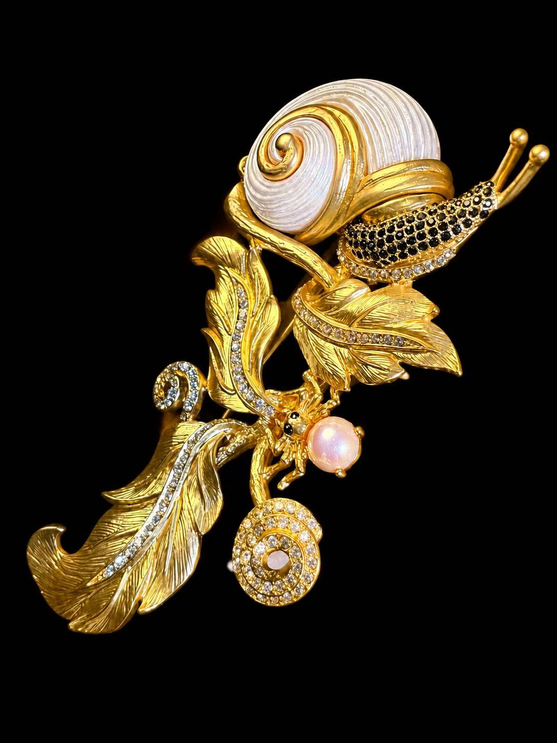 Gold-tone snail and leaf statement brooch angled view with shell-style detail