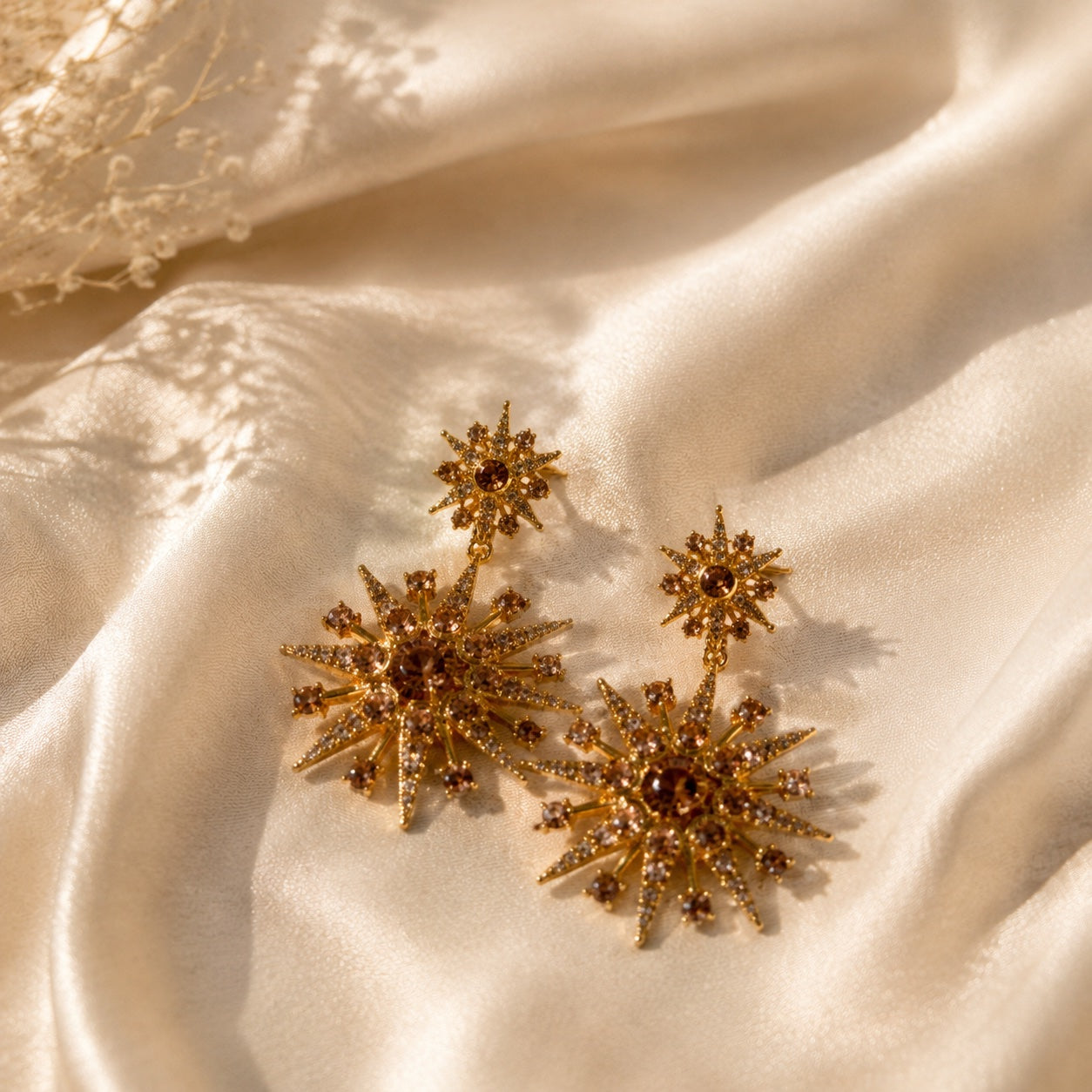 Gold-tone starburst crystal-style-style stud earrings champagne color front view