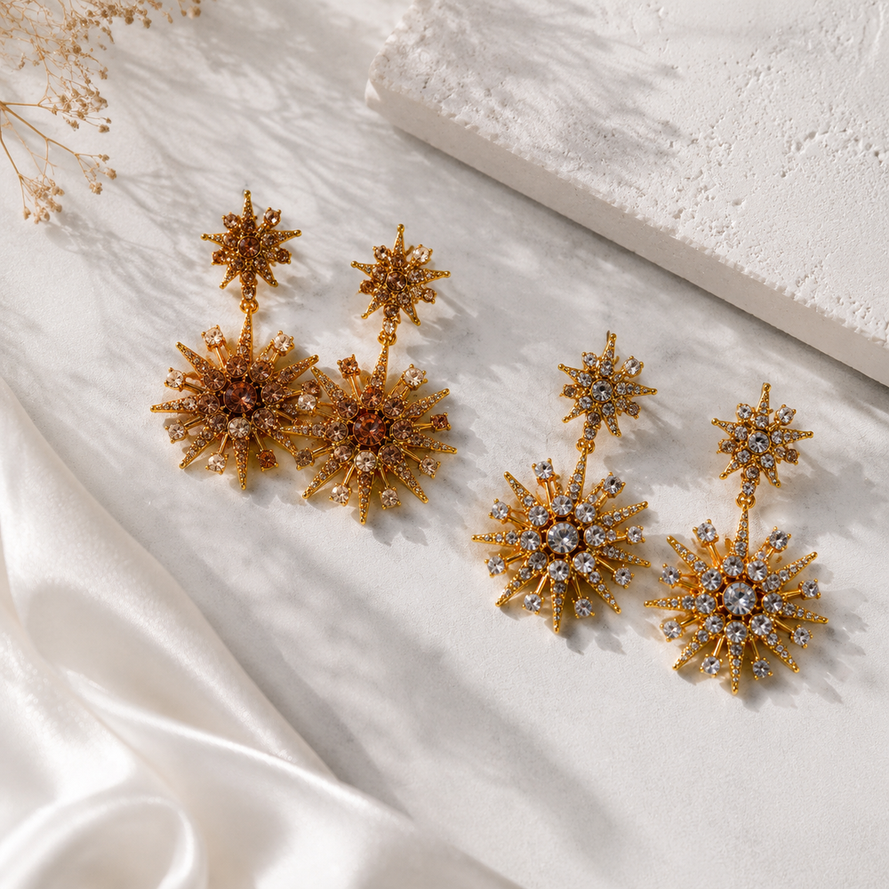 Gold-tone starburst crystal-style stud earrings in champagne and clear colors