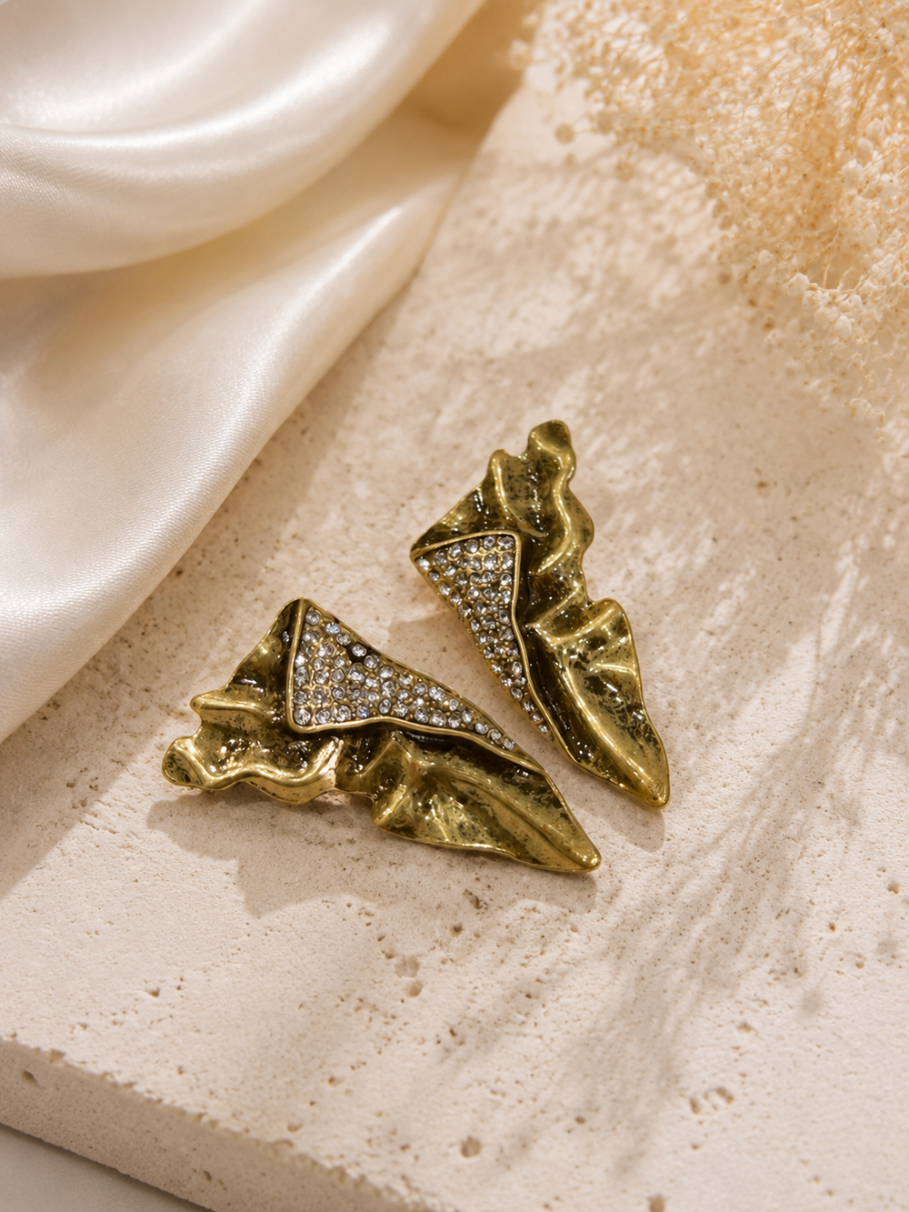 Pair of gold-tone vintage-inspired geometric stud earrings with clear crystal-style accents, front view