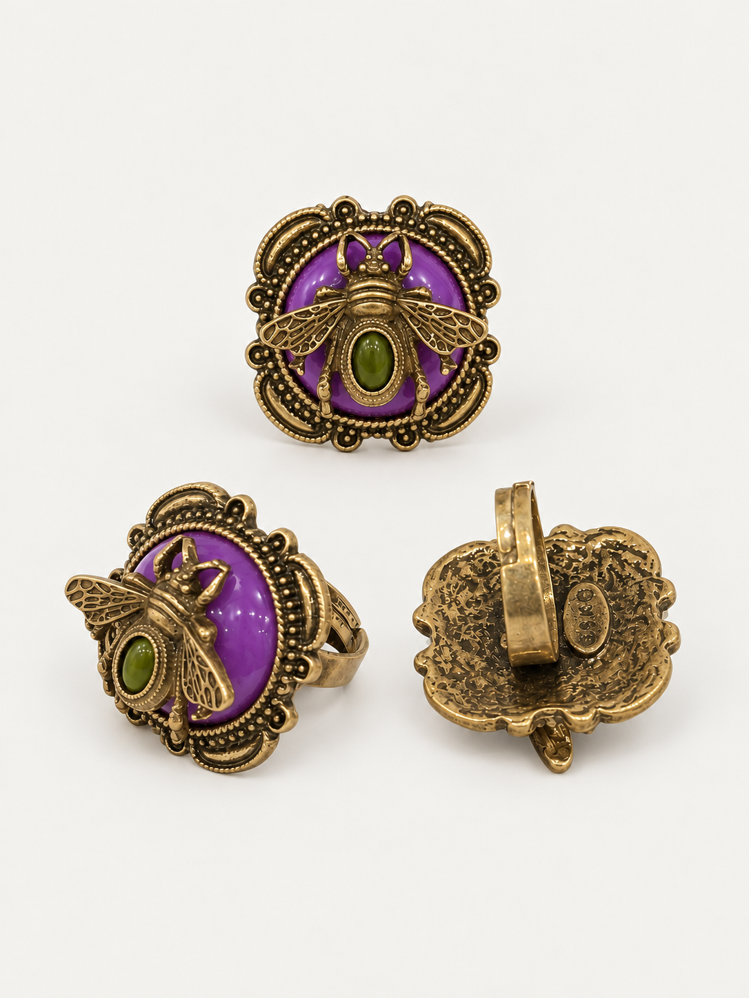 Gold-tone adjustable ring with an ornate honey bee motif, purple stone-style accent, and green cabochon-style center, front and back view