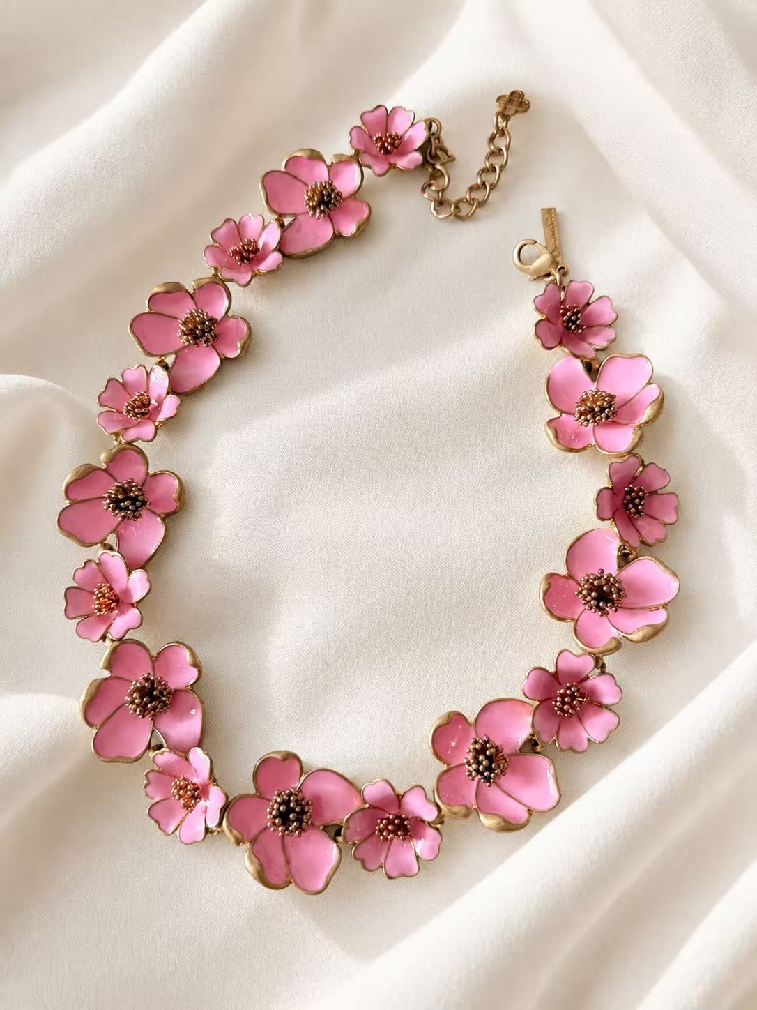 Pink enamel floral statement necklace on ivory fabric