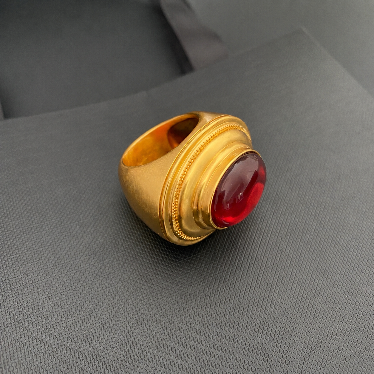 Brass ring with red oval accent angled view