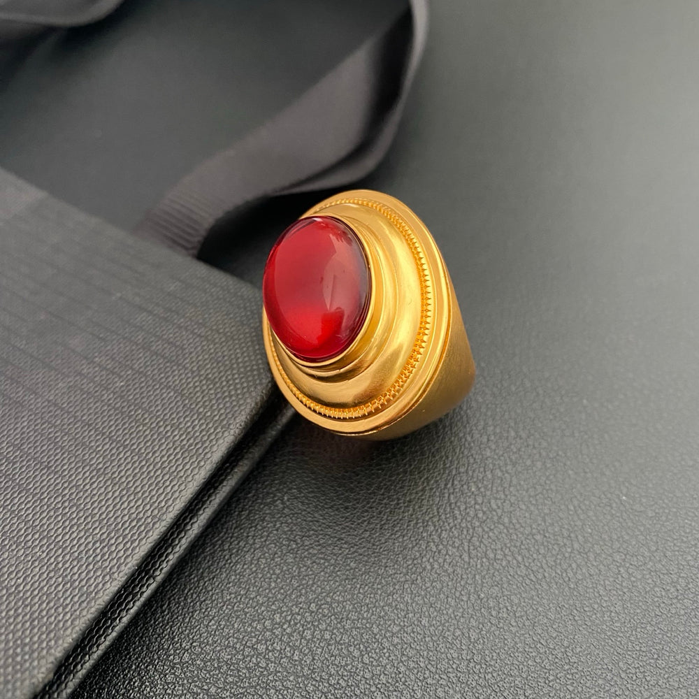 Brass ring with red oval accent on black display