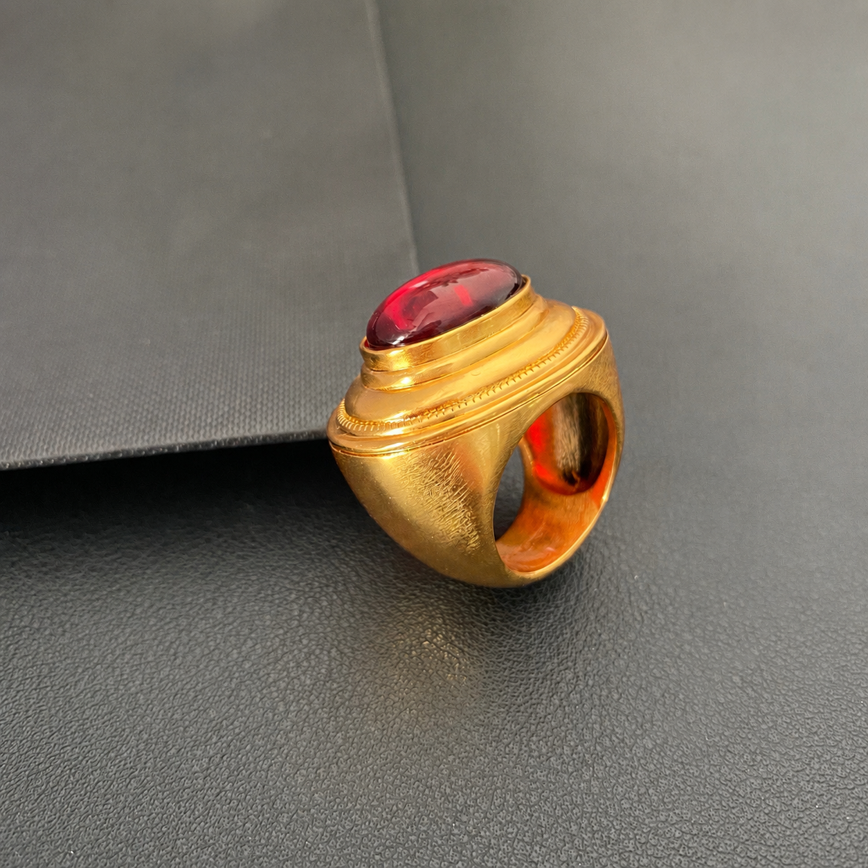 Side view of brass ring with red oval accent