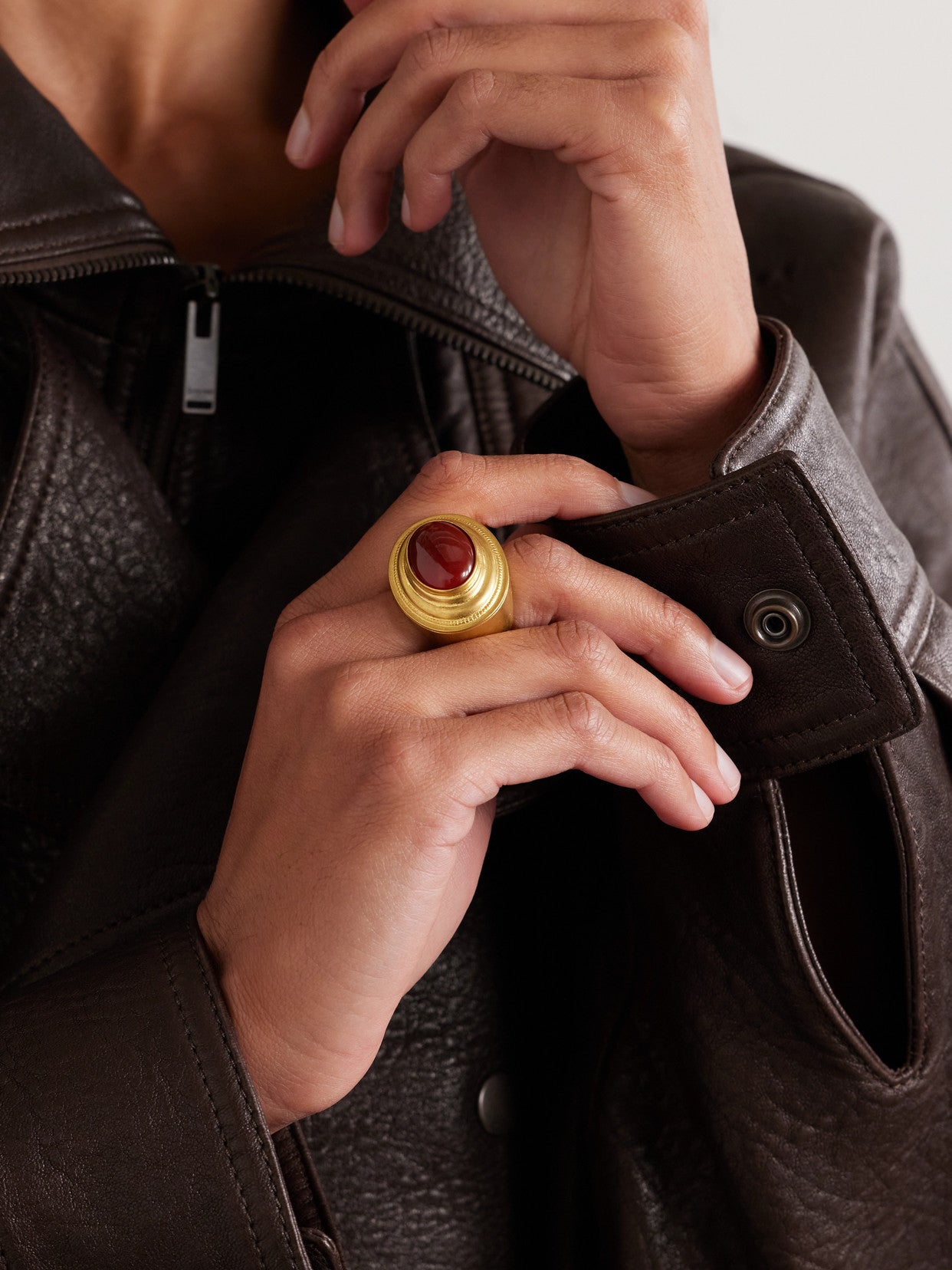 Brass ring with red oval accent worn on hand