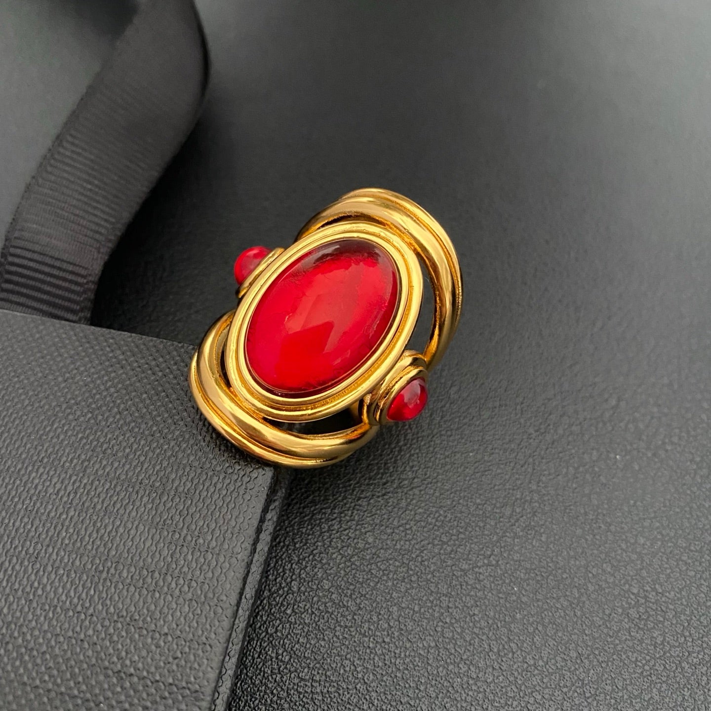 Brass ring with a red oval accent on a black display