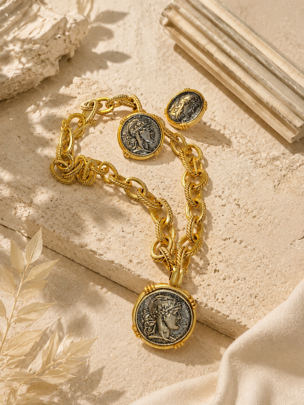 Gold-tone ancient coin-style necklace and stud earrings set flat lay