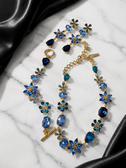 Blue gold-tone glass flower and teardrop jewelry set flat lay