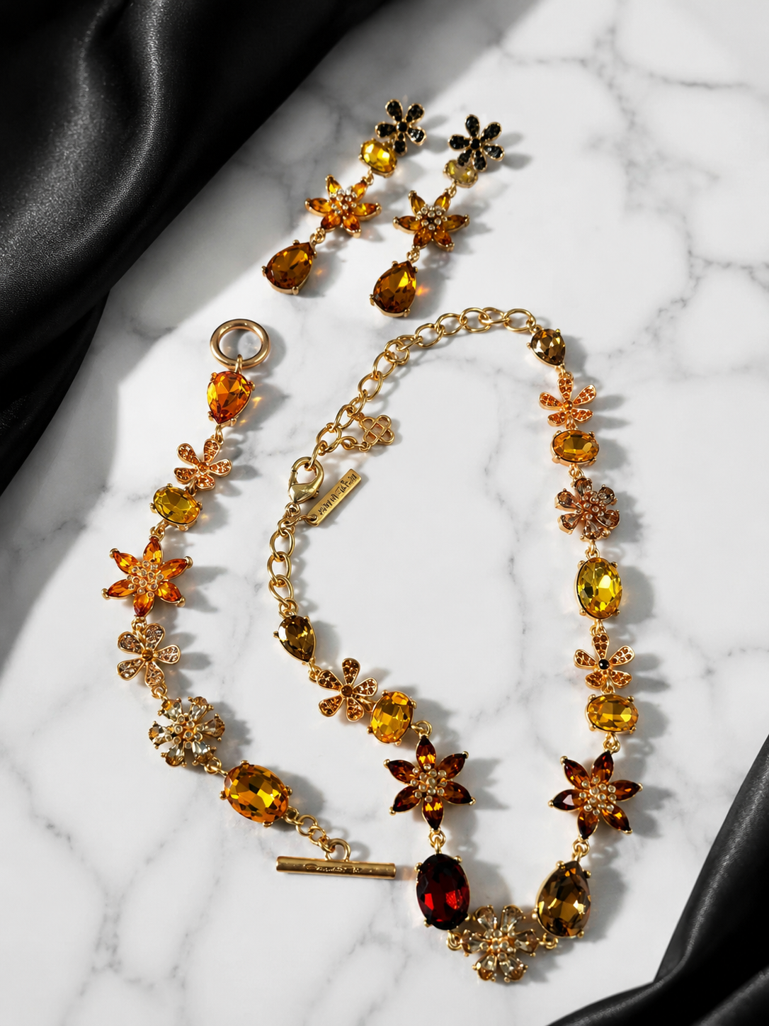 Orange gold-tone glass flower and teardrop jewelry set flat lay