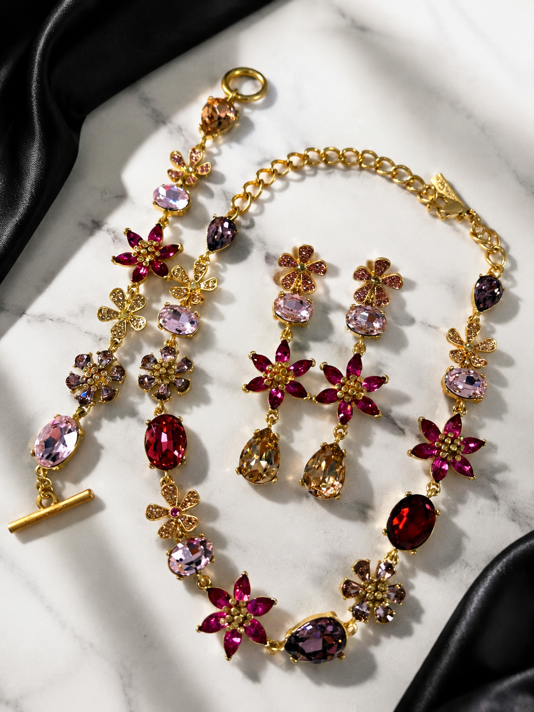 Rose red gold-tone glass flower and teardrop jewelry set flat lay