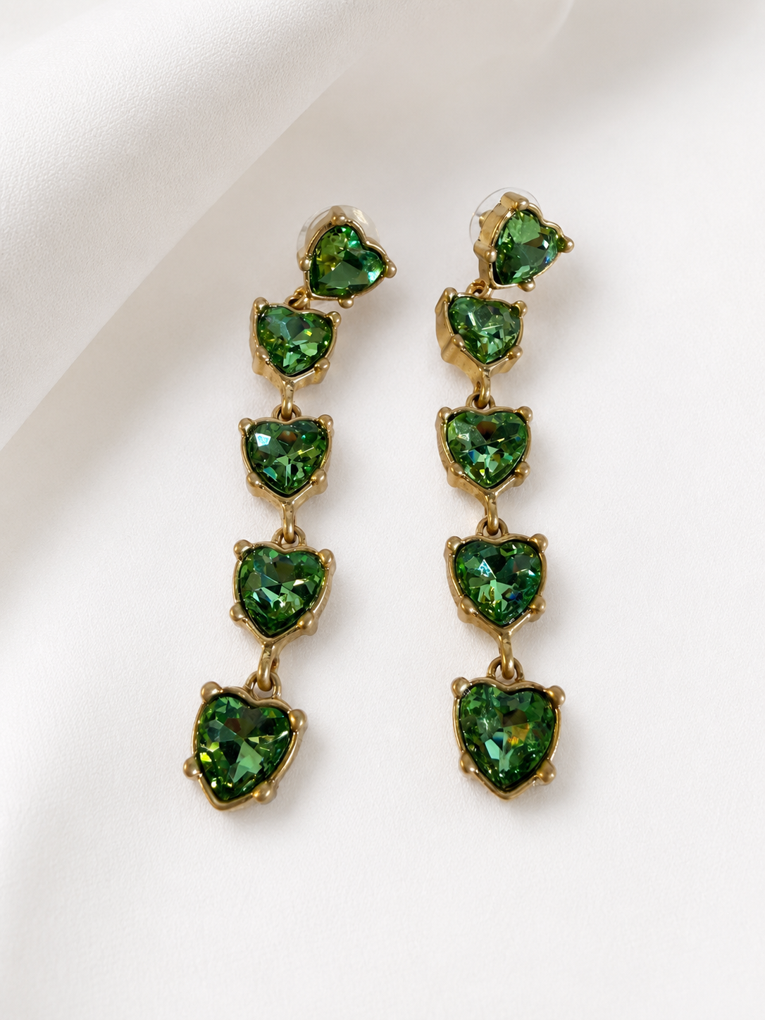 Gold-tone green crystal-style heart drop earrings close view