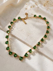 Gold-tone green crystal-style heart necklace detail view